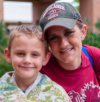 A woman and a boy smiling for the camera